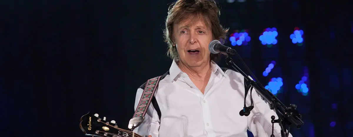 Paul McCartney singing while playing guitar