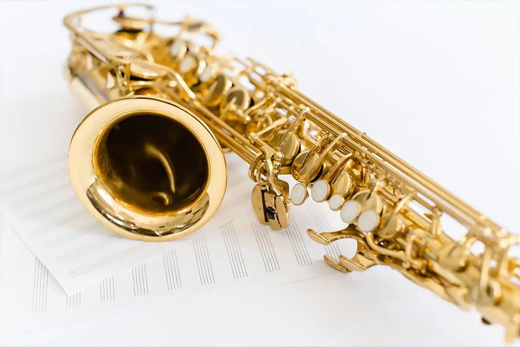 Gold saxophone resting on music paper