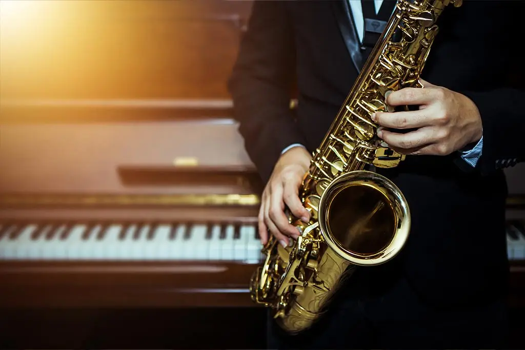 Saxophone player with piano on the background