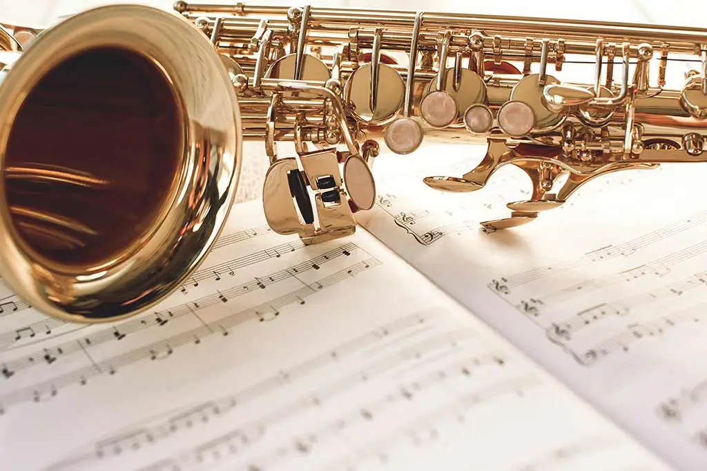 Saxophone with bell facing left on open sheet music