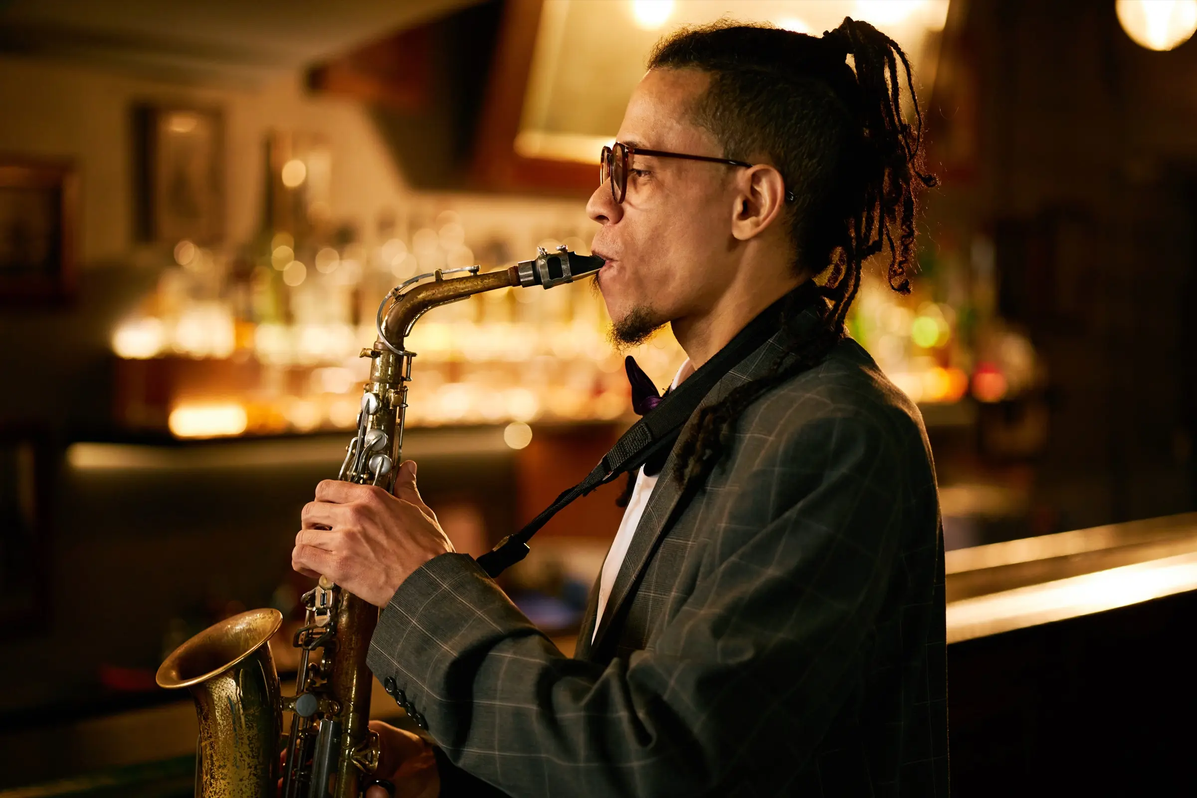 Saxophonist in a checked suit playing in a jazz bar.