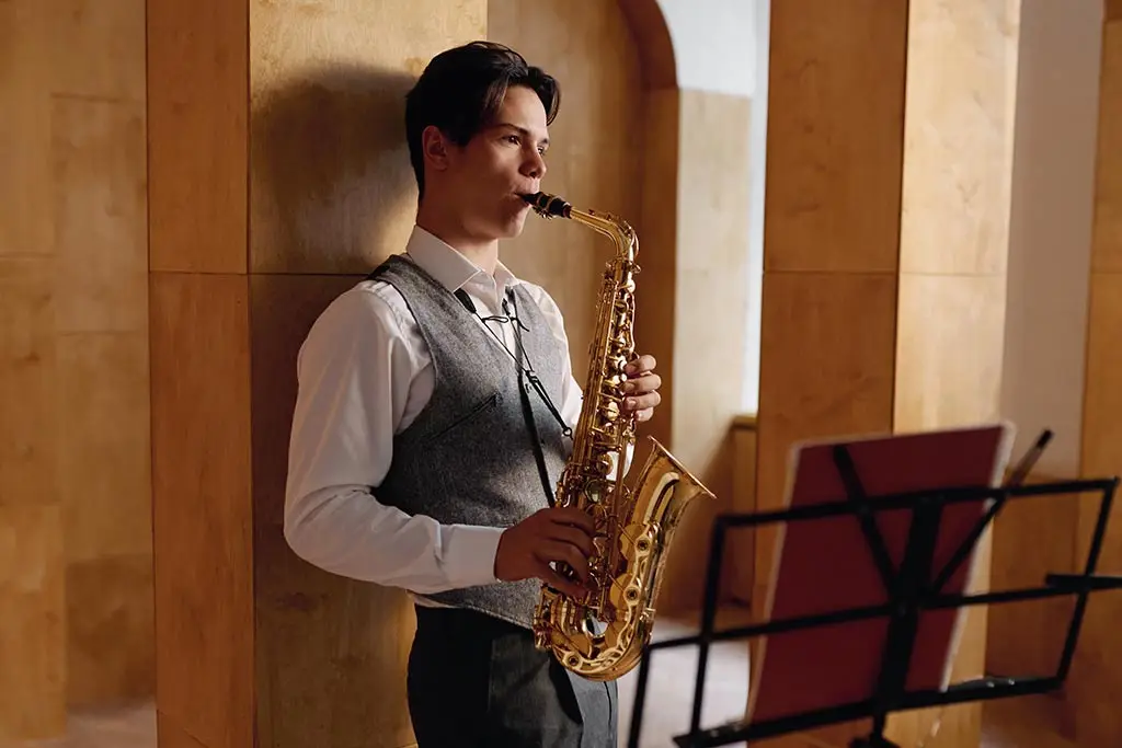 Saxophonist playing alto saxophone beside a music stand