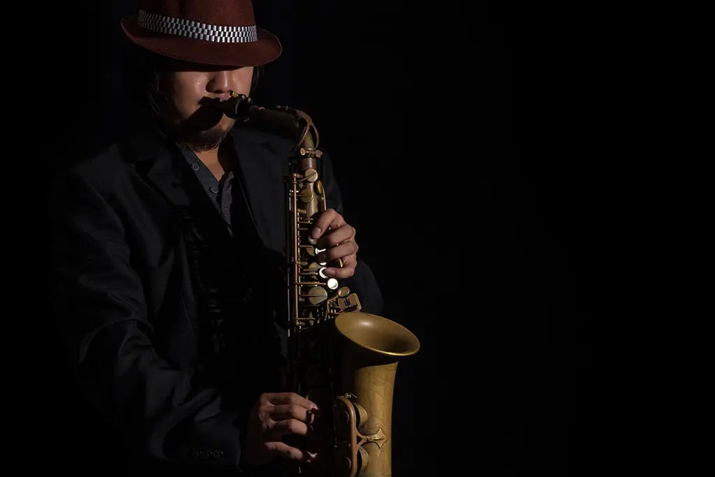 Saxophonist in a hat playing tenor saxophone