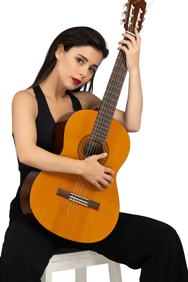 Seated woman in a black top holding a classical guitar
