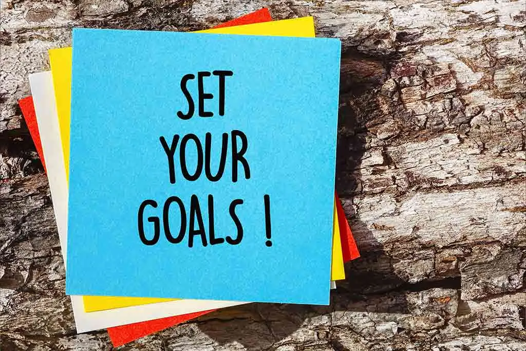 Sticky notes reading Set your goals on tree bark