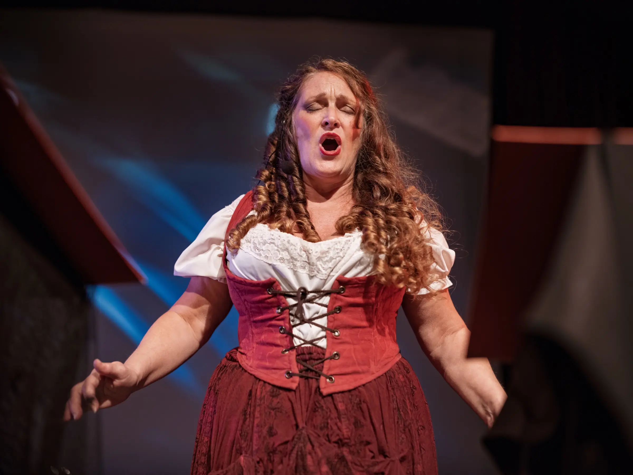 Singer in a theatrical costume performing on stage.