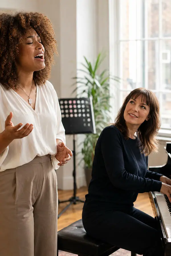 Singer performing beside a pianist at the piano