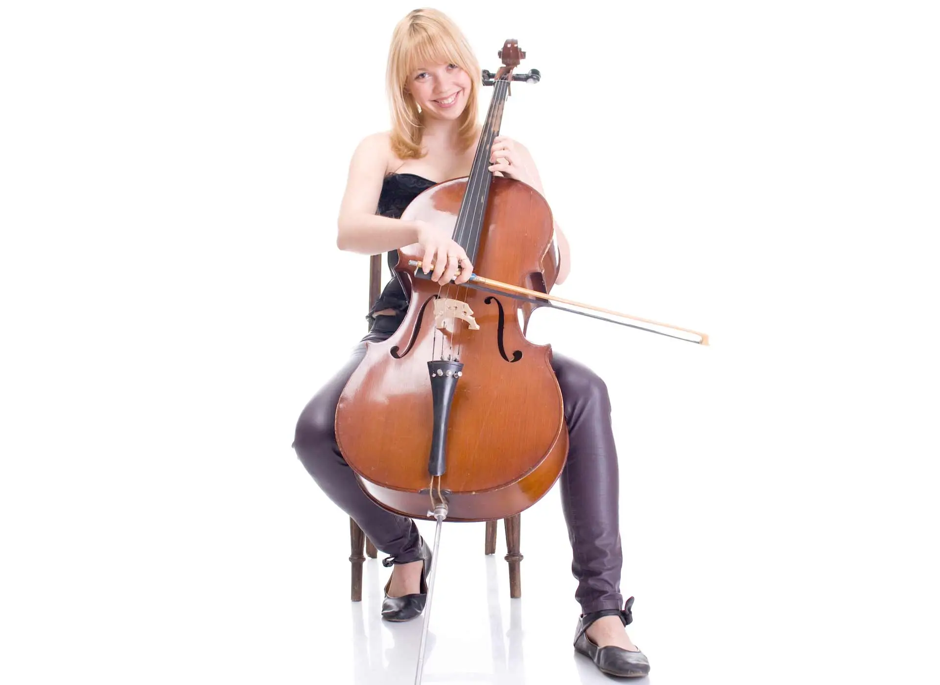 Smiling woman seated and playing a cello