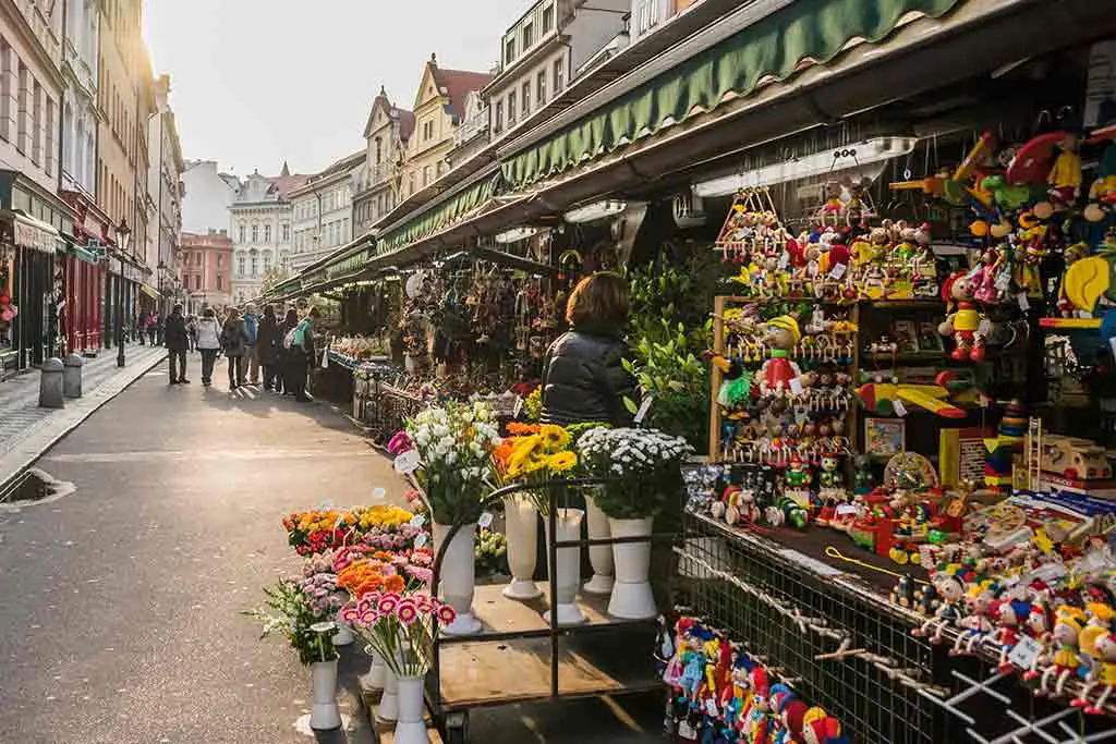 Street market stalls selling flowers and colourful toys