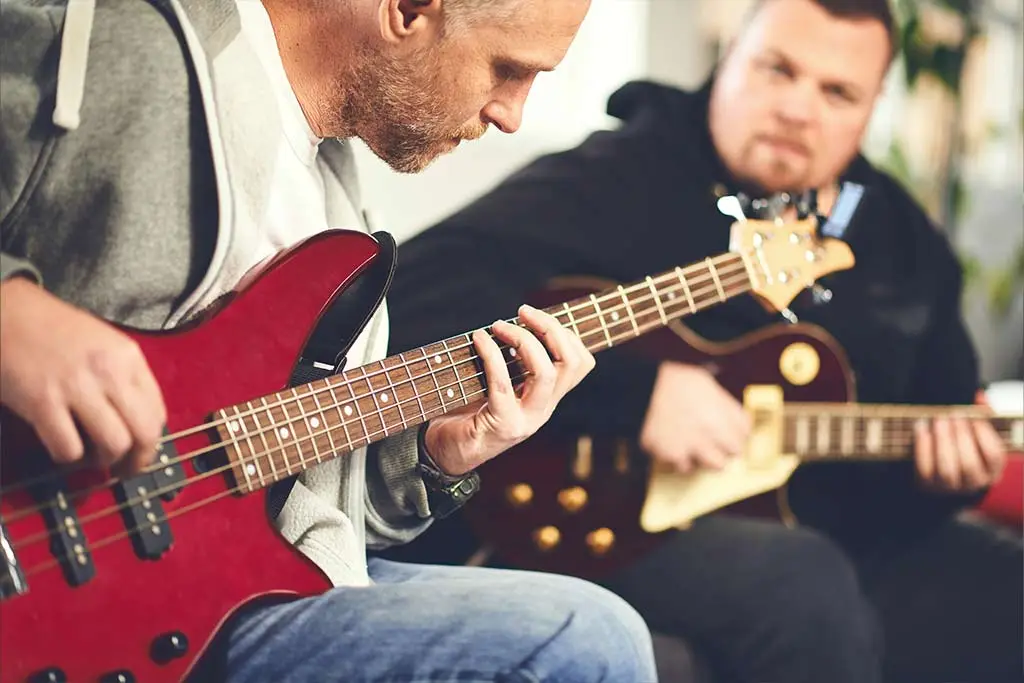 Two musicians playing bass and electric guitar
