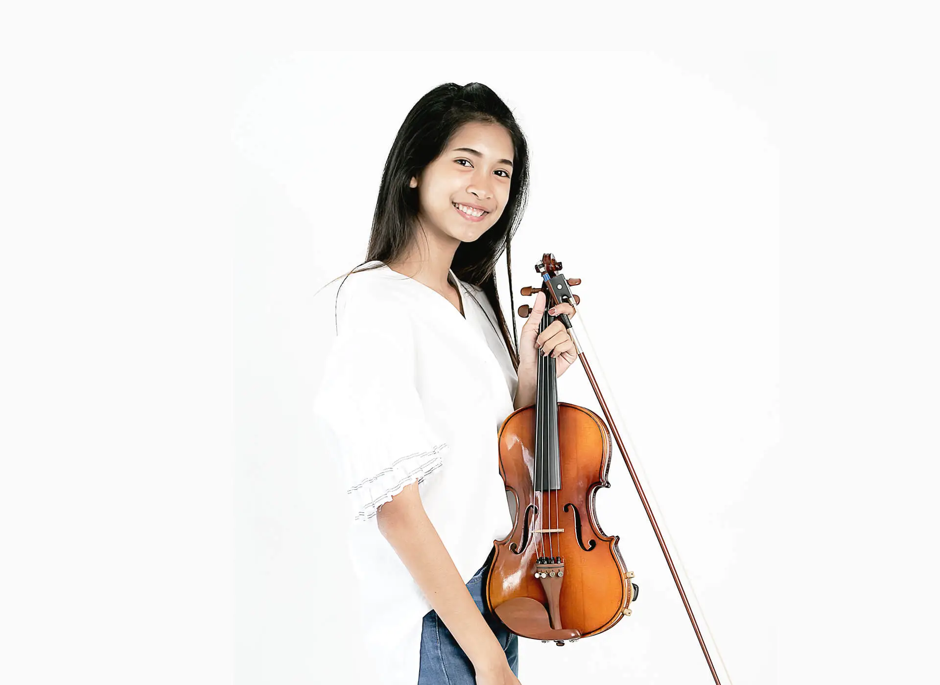 Woman holding a violin and bow against a white background