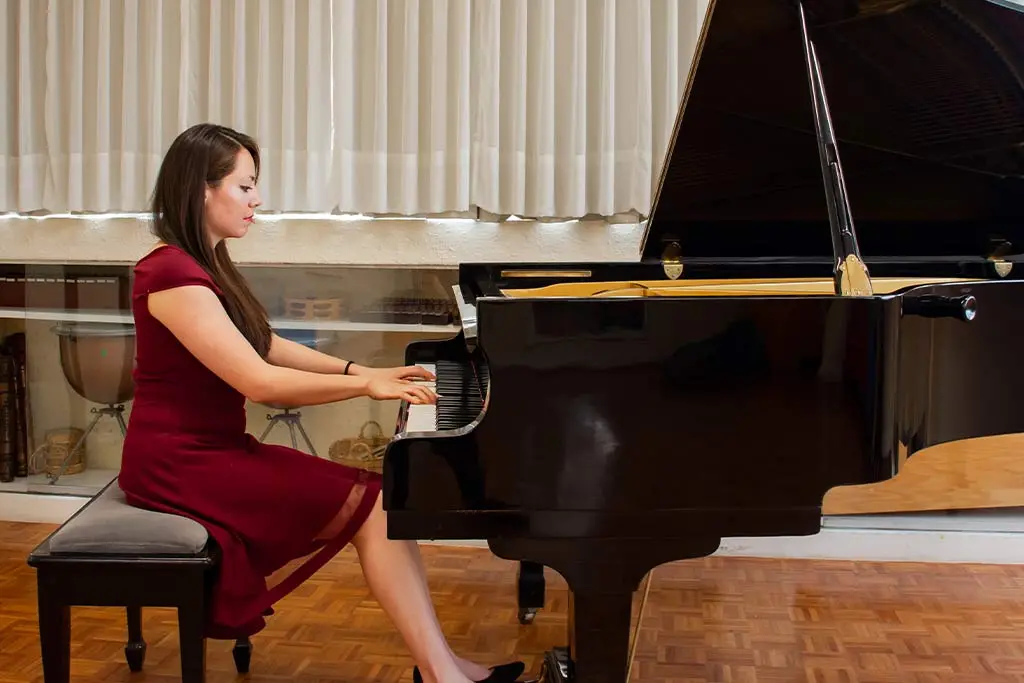 Woman in red dress playing the grand piano