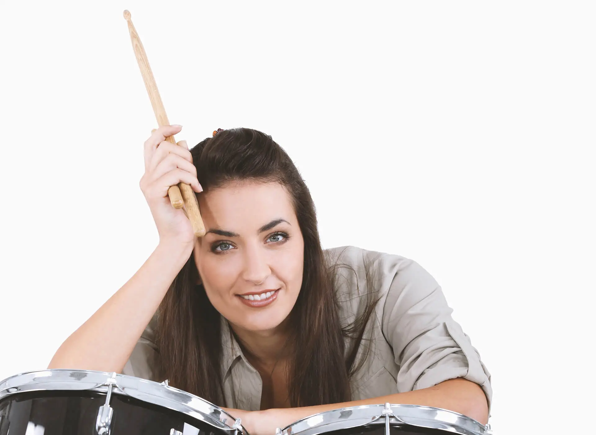 Woman leaning on a drum kit holding drumsticks