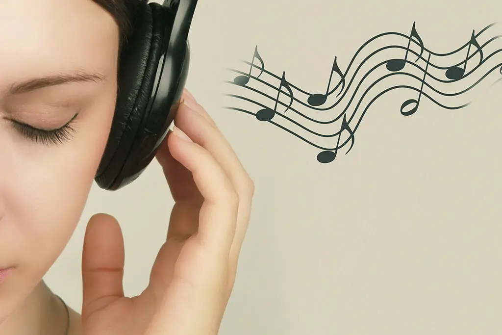 Woman with eyes closed listening through headphones beside musical notes