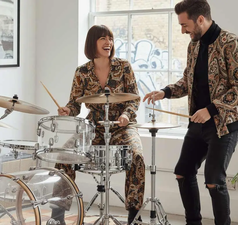 Drum student laughing at the kit while her teacher plays along