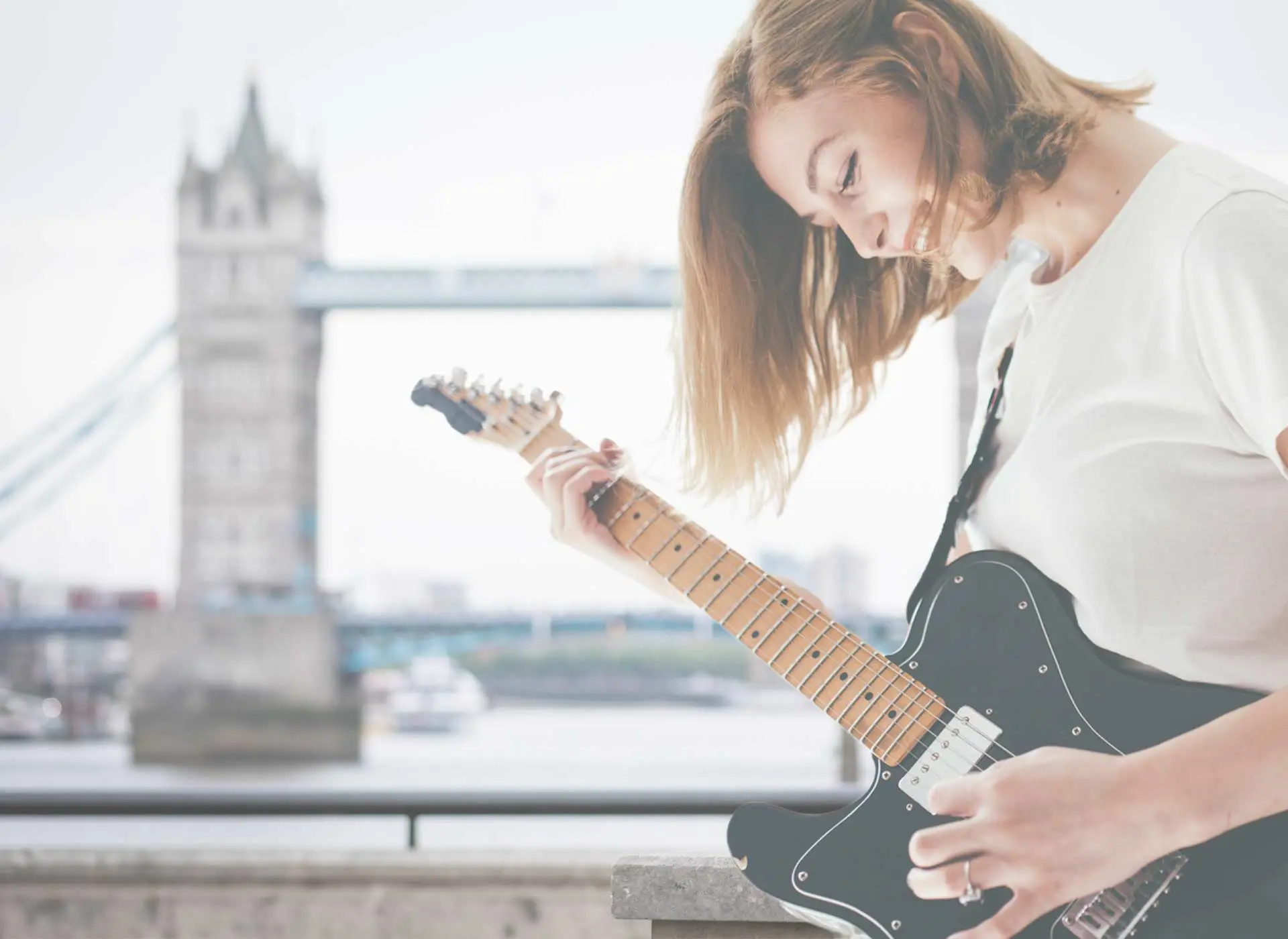 A woman playing an electric guitar in London