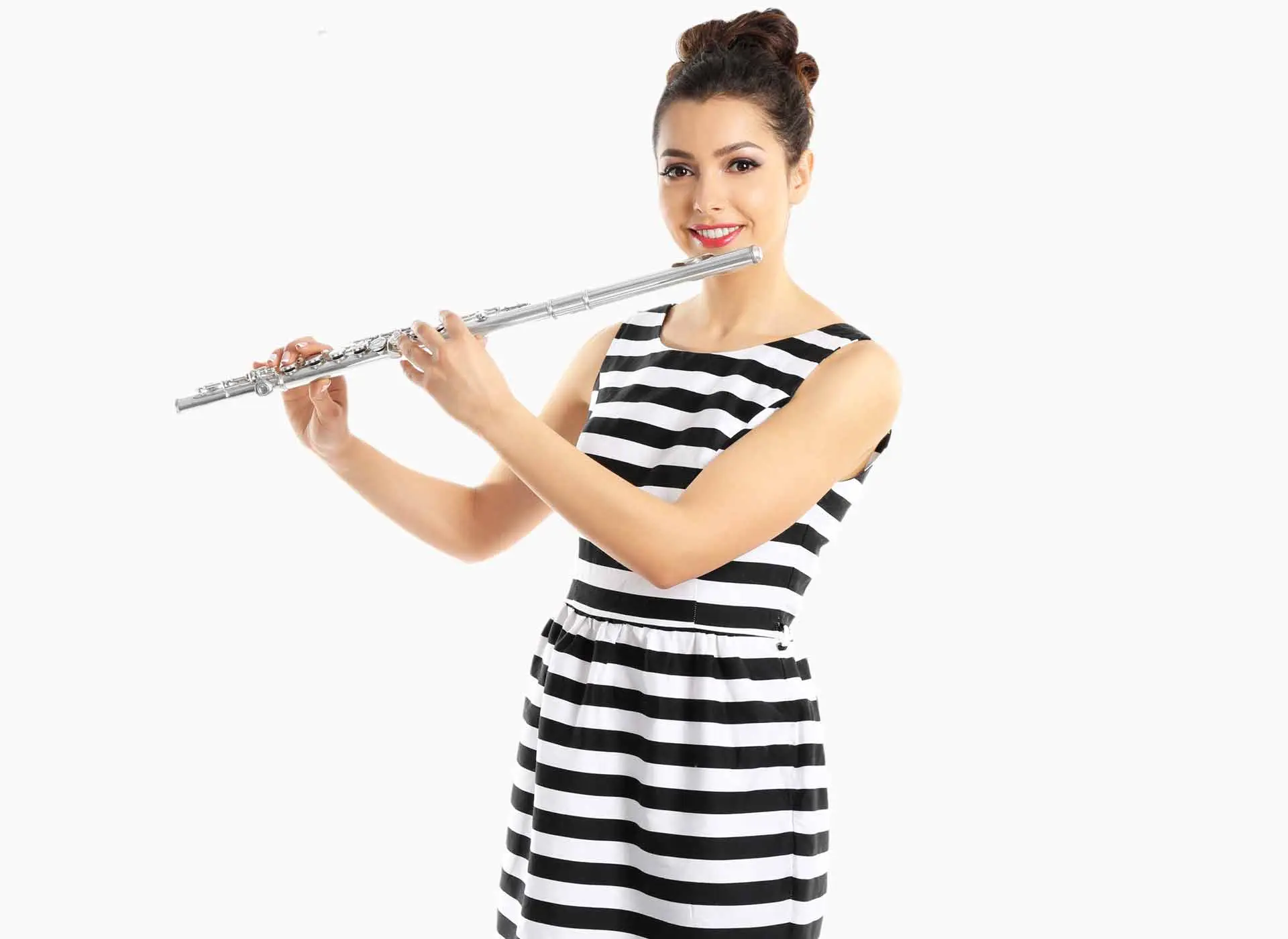 Smiling woman playing a silver flute in a striped dress