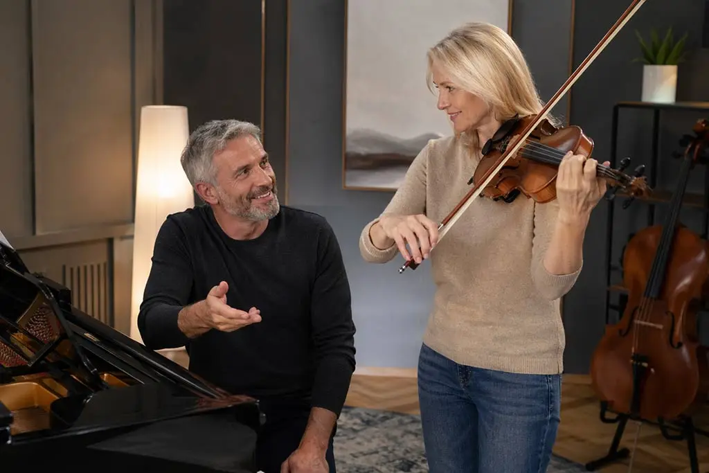 Woman playing violin beside a seated man at a grand piano