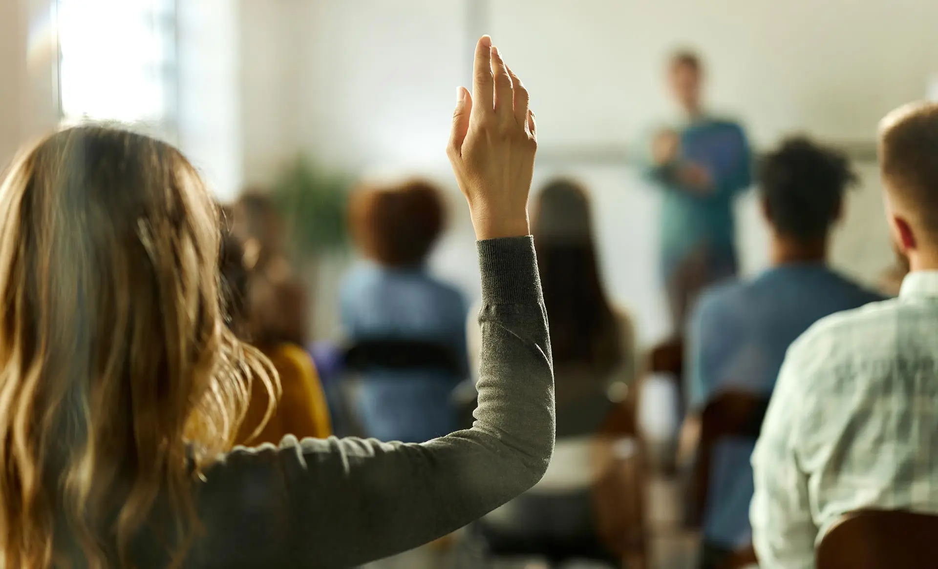 A student raising her hand to ask a question
