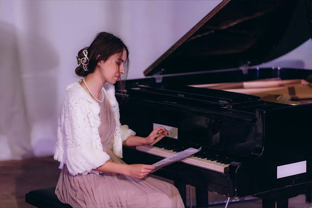 Woman reading sheet music at a grand piano