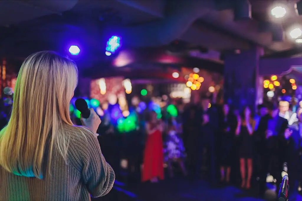 Woman singing on stage with audience