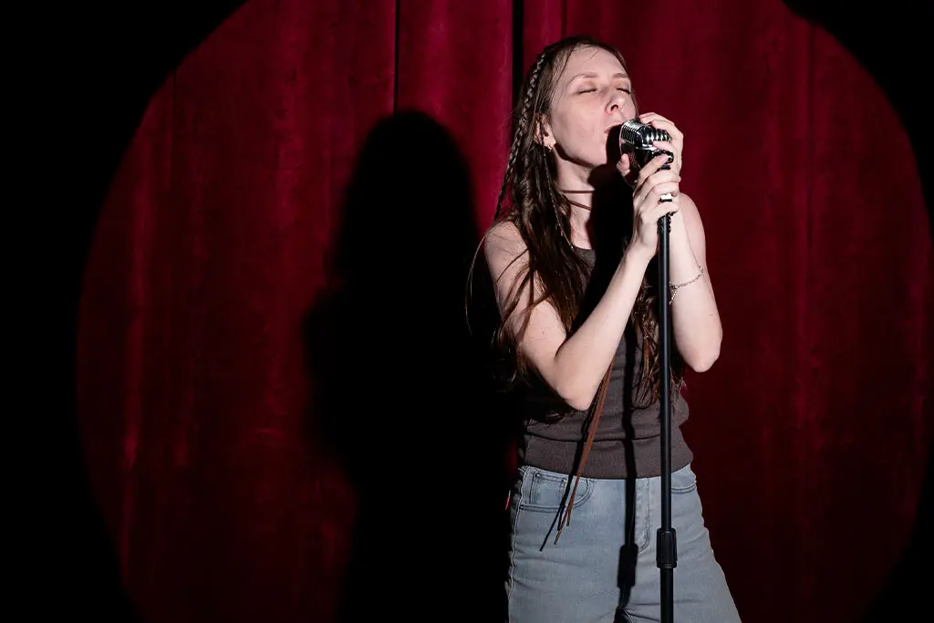 Woman singing on stage with spotlight