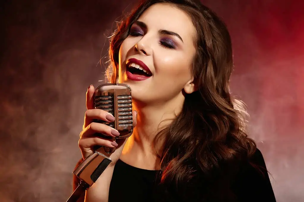 Woman singing into a vintage microphone against red smoke