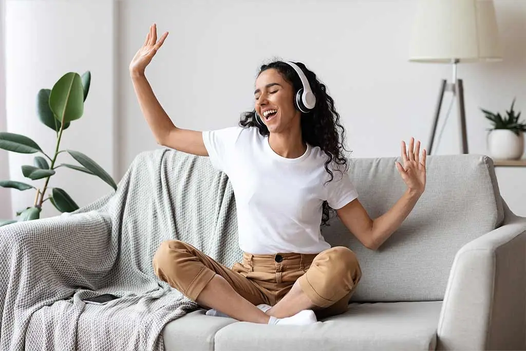Woman sitting on the couch listening to music