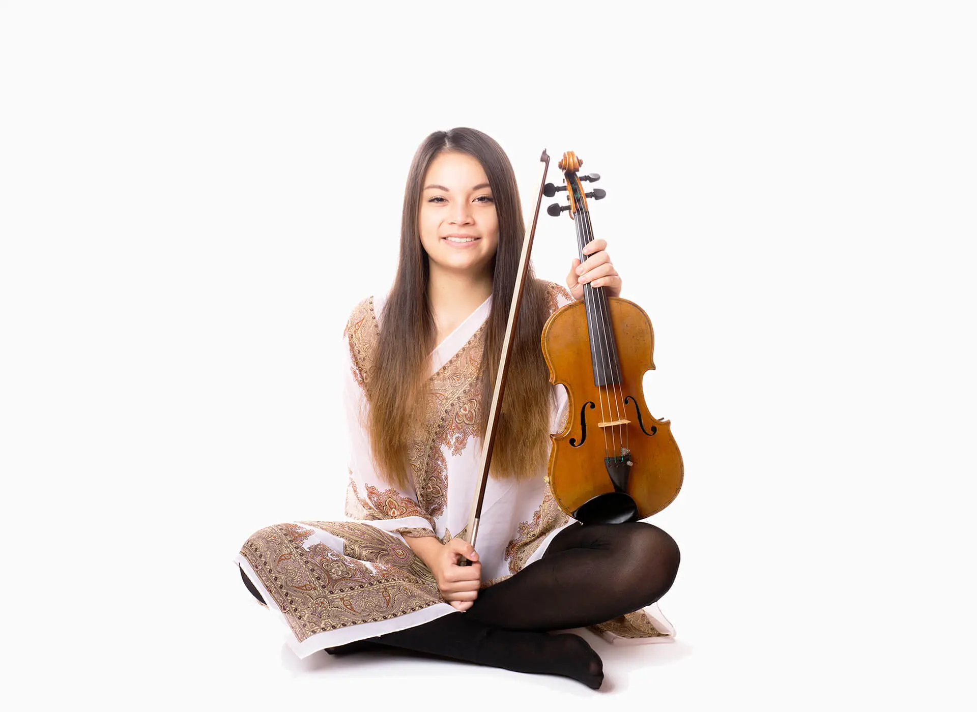 Woman sitting cross-legged holding a violin and bow