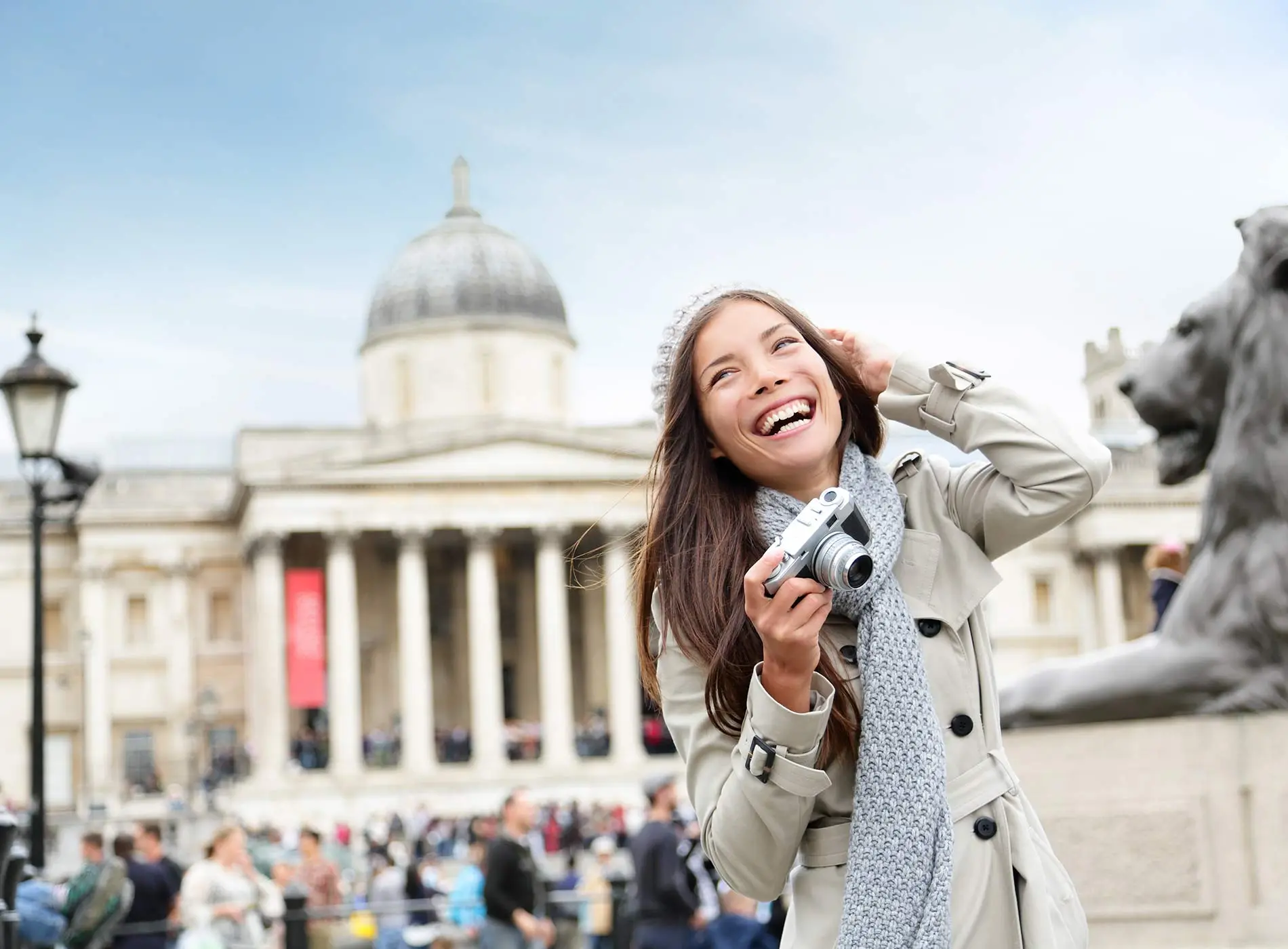 Happy woman holding a camera in front of national gallery