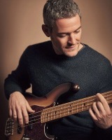 A man playing an electric bass guitar